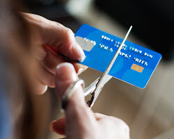 person cutting up their credit cards