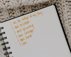 Person writing positive affirmations