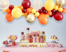 candy buffet with a centerpiece, such as a balloon arch