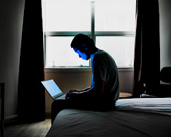 person sitting alone in a room with their phone