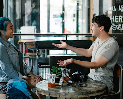 person sitting at a table with locals, drinking tea and laughing