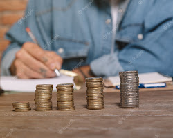 person writing down expenses in a notebook